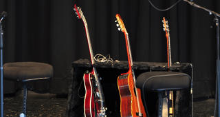 Drei Gitarren im Ständer auf der Bühne